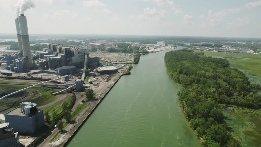 Aerial view of a river flowing near an industrial area in the plains