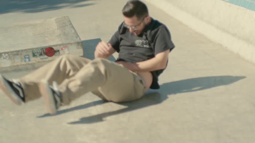 A man crashes while riding his skateboard