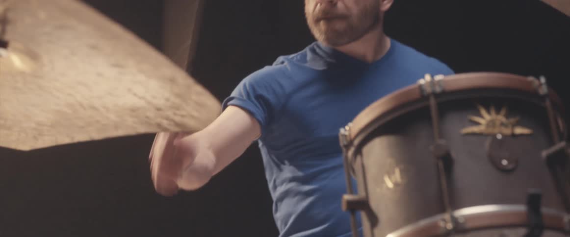 A man plays drums with his drumming sticks