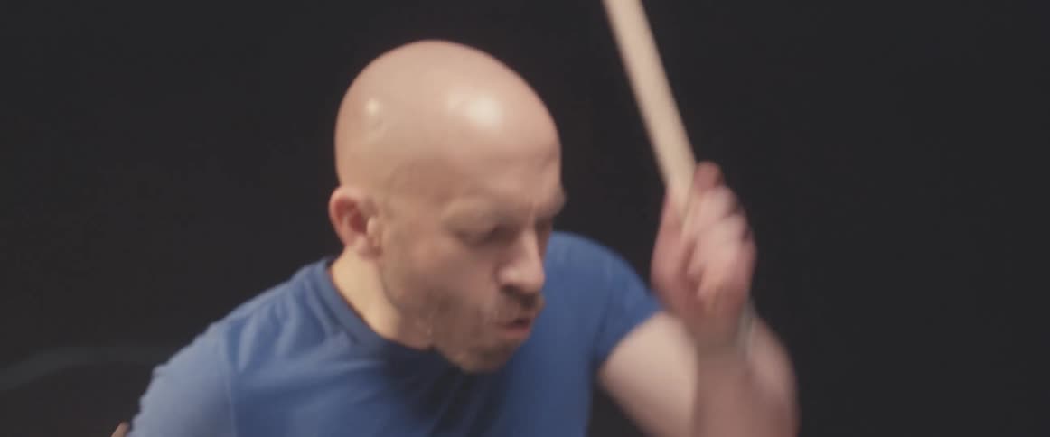 A man practicing drums in a studio