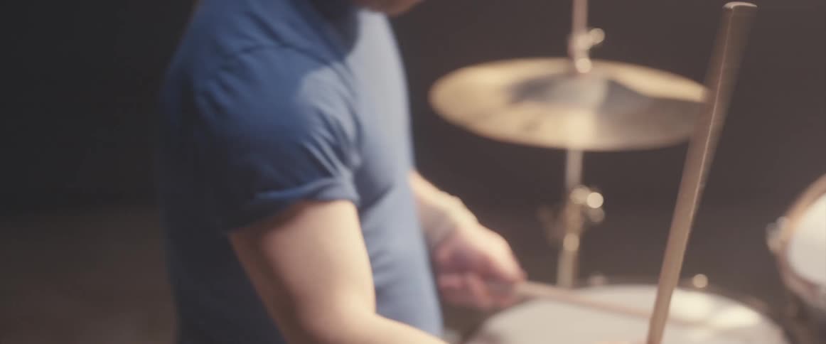 A man is playing the drums in a room