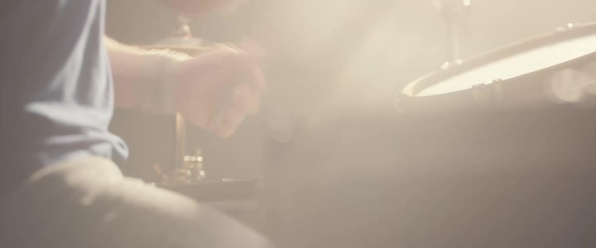 A man is playing the drums instrument indoors