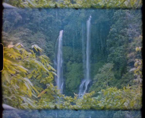 A double waterfall flows down a lush green cliff