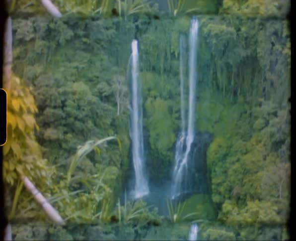 Waterfall cascades down cliffside in the jungle