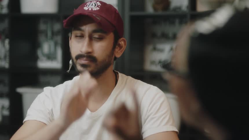 A man talks with an older woman while sitting indoors
