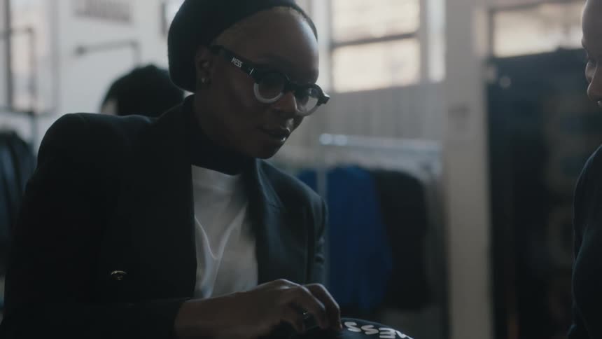 Boss checks the quality of printed t shirts on a factory with a worker