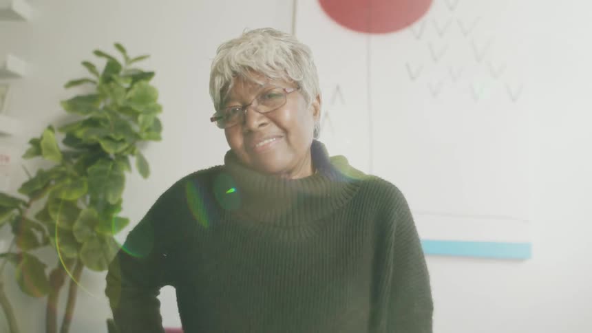 Elderly woman standing on the living room at home looking at the camera