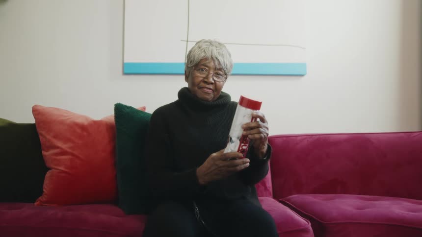 A woman is smiling while holding a gift