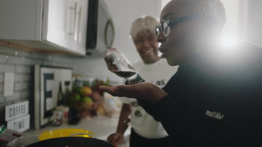 Mother and daughter cooking soup together on the kitchen at home