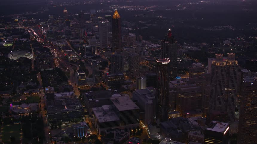 Skyscrapers are lit up at night in a bustling downtown