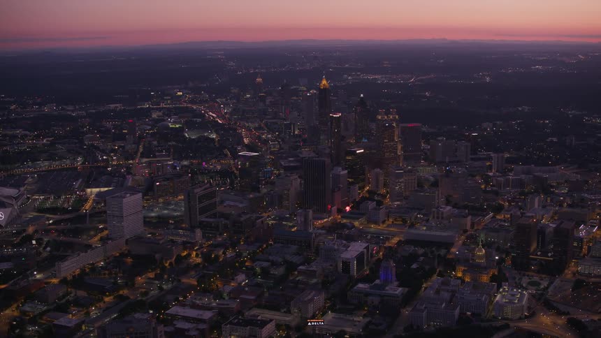 Lights shine across cityscape under red sky