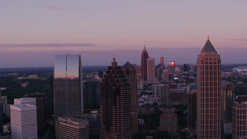 The sun shines brightly on tall buildings and skyscrapers overlooking a big city