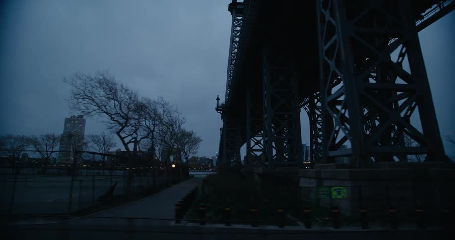 The sun is setting by the bridge