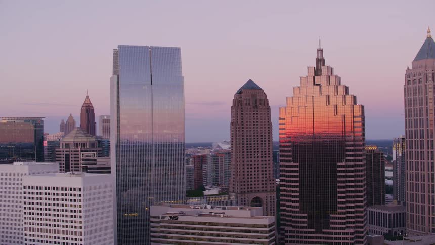 The sun shines brightly on tall buildings and skyscrapers overlooking a big city