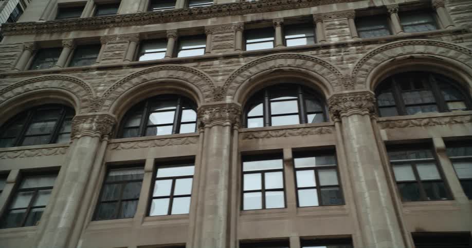 Buildings reflect off the mirrored windows of a building across the street