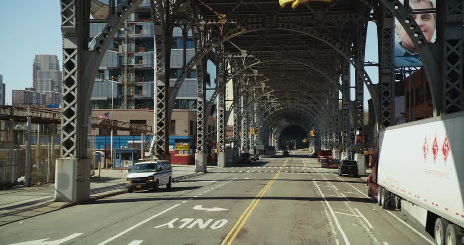 A traffic light stays green under a bridge near downtown