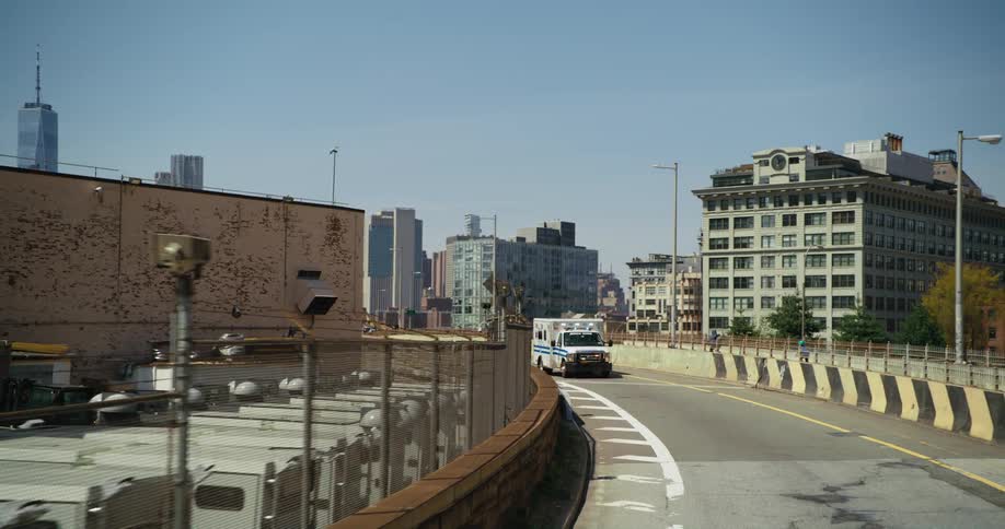 An ambulance drives down a curved road near downtown