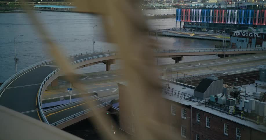 Footage of new york city highways seen through the beams of a bridge