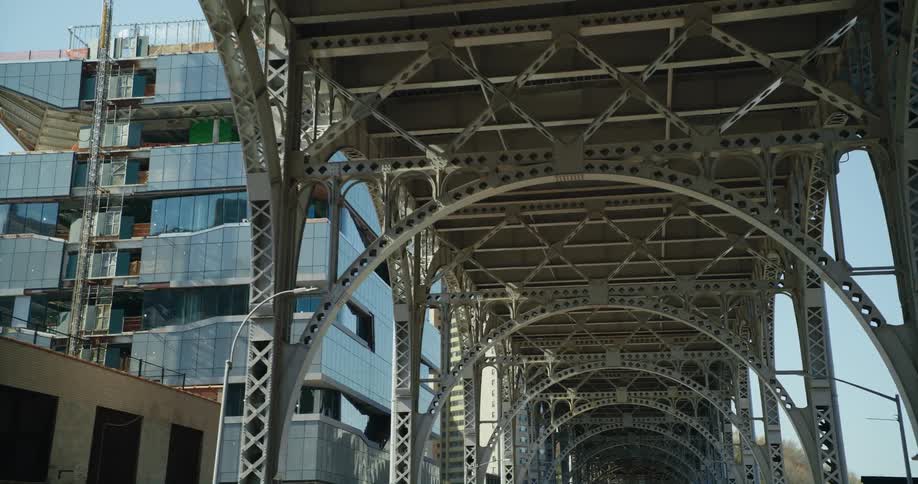 A look at a bridge in a city with multiple buildings visible at a distance