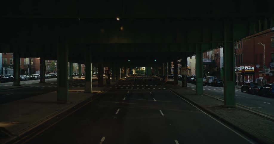 Traffic sits at intersection on street paralleling overpass