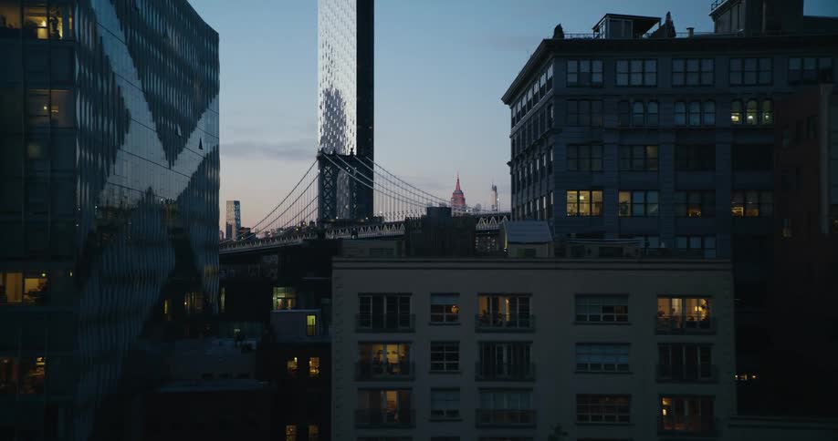 Car drives along overpass passing apartment buildings with large suspension bridge in the background