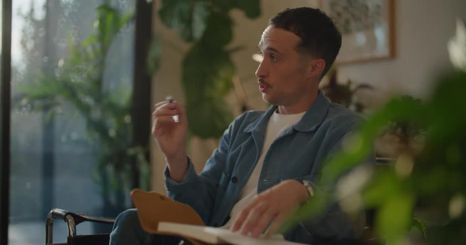 A man is talking and writes in a notebook