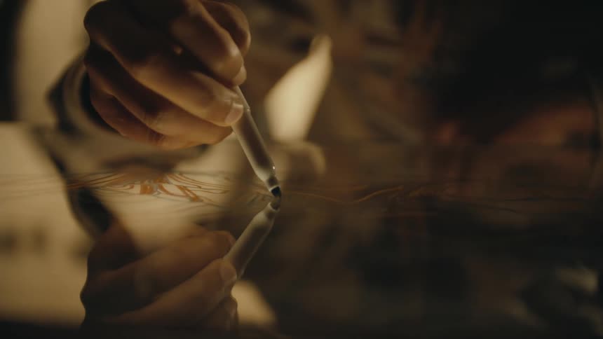 Close up of the hand of a designer drawing with a marker over glass