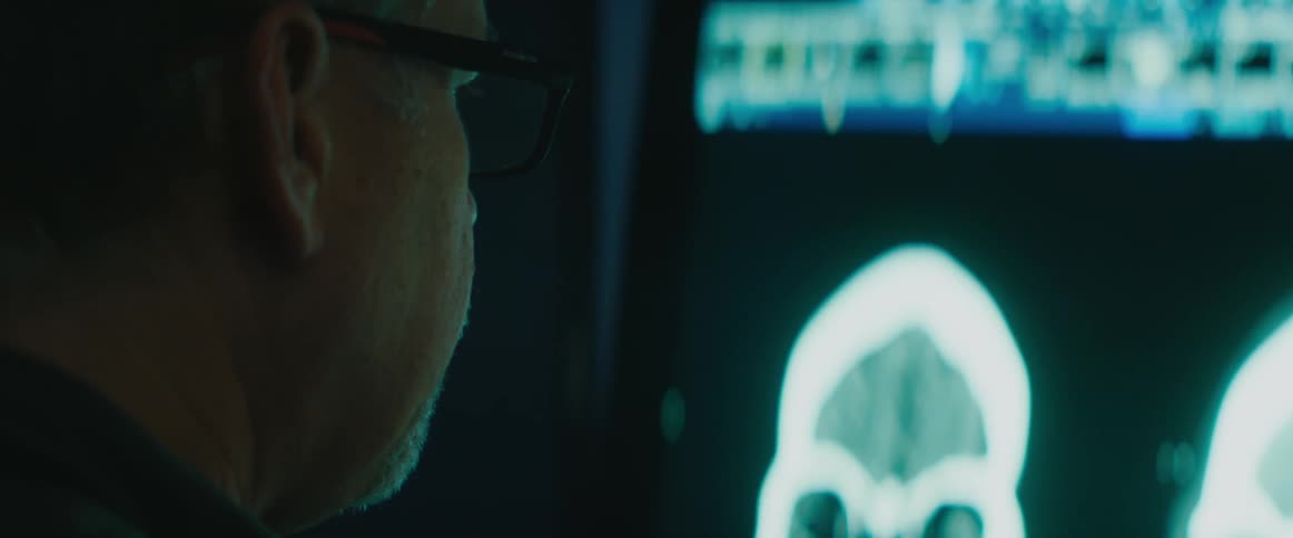 A man is looking at an image on a monitor screen