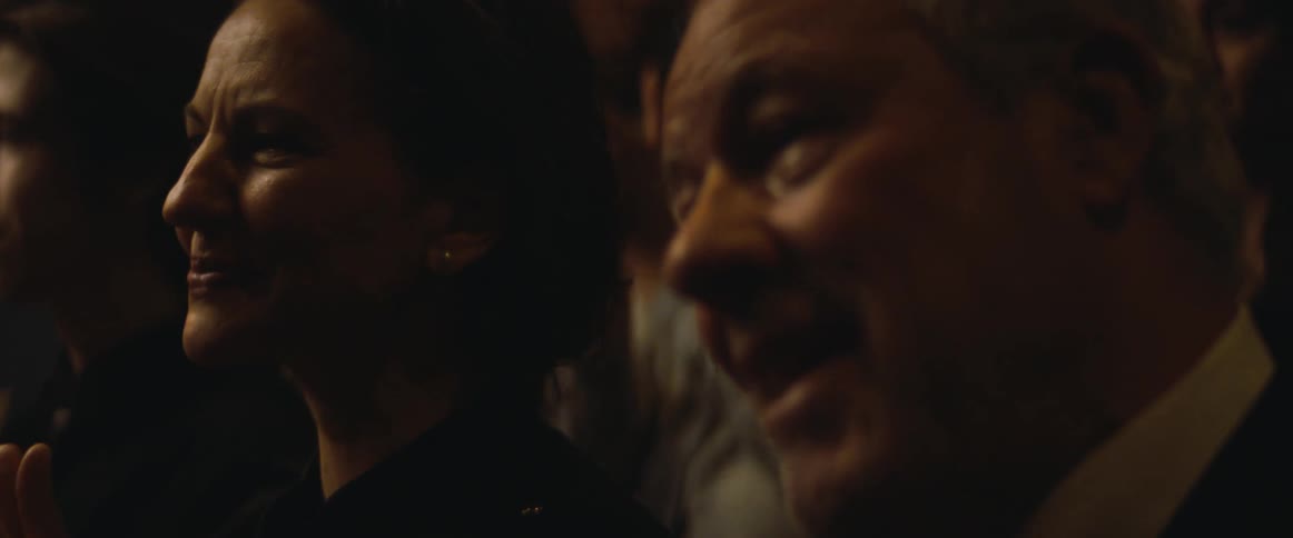 A man sitting in the audience wiping away his tears as he watches a performance