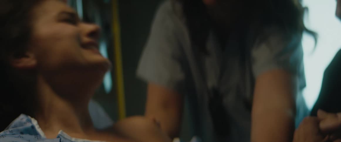 Husband holds wifes hand as she strains to give birth in hospital bed