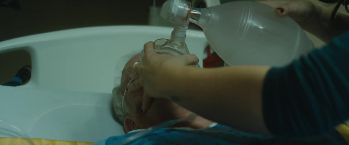 Doctors and nurses try to revive an elderly man laying in bed at a hospital