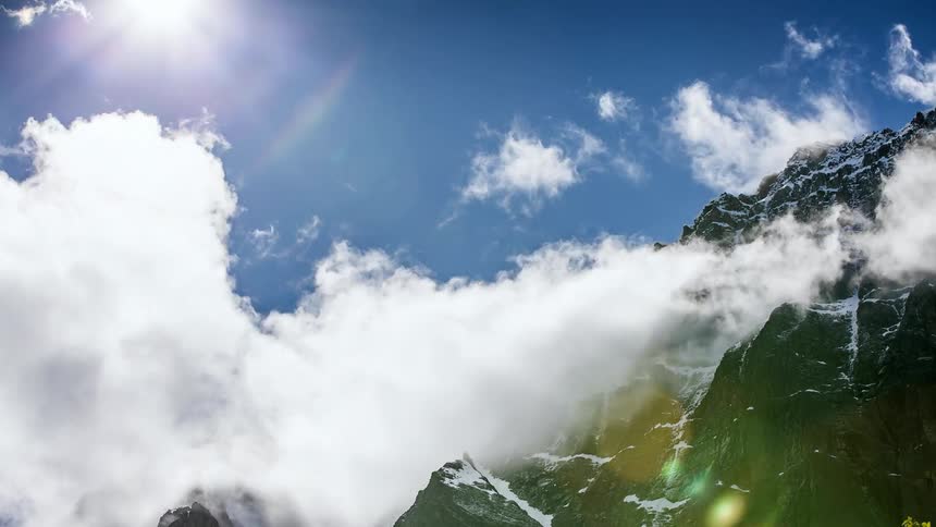 Clouds move around on the side of a mountain
