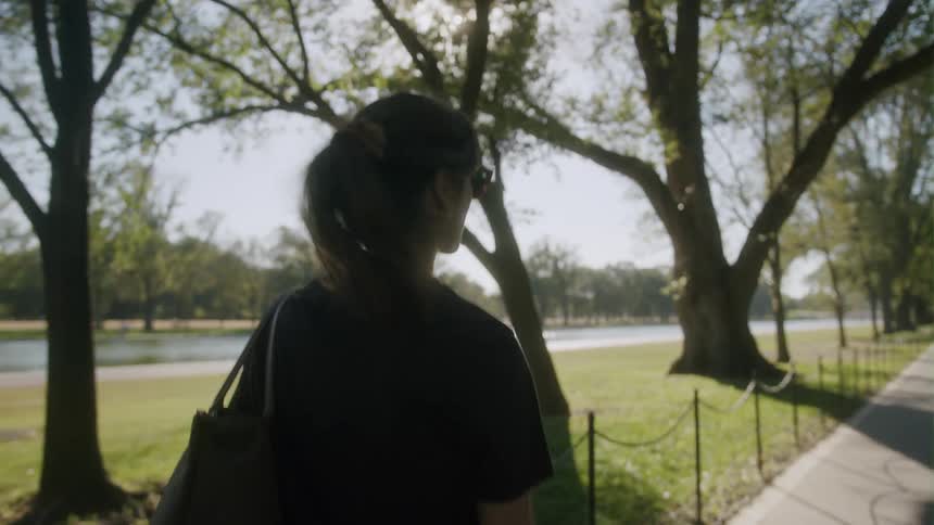 A woman is walking outdoors in spring during the day