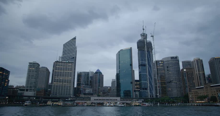 City skyscrapers next to sea under cloudy sky