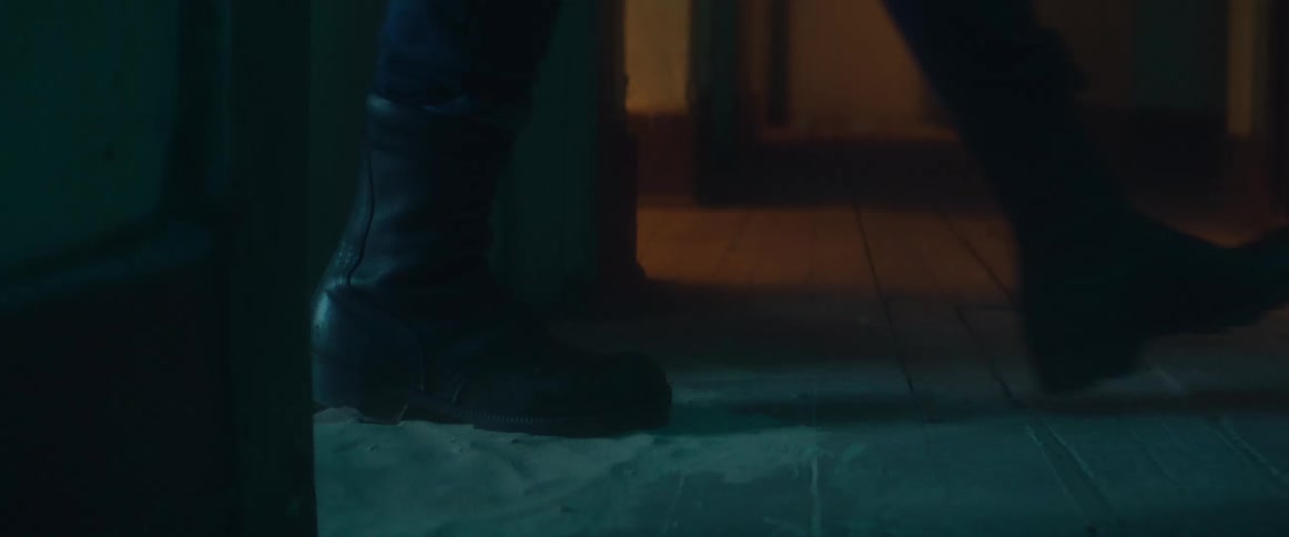 A person stepping out of a building at night