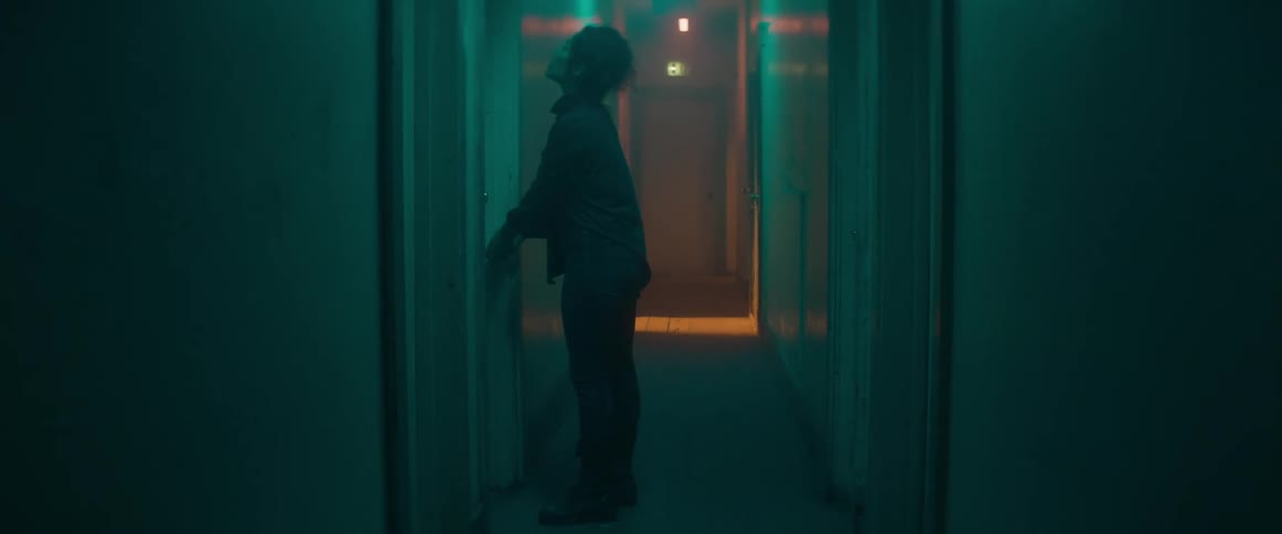 A woman is walking and opening doors in a hallway