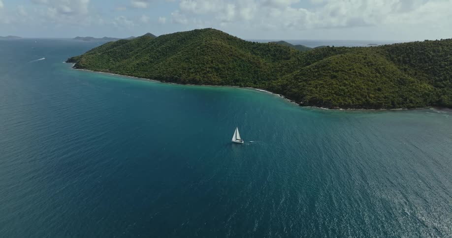 Aerial view of a boat driving in the ocean water is displayed