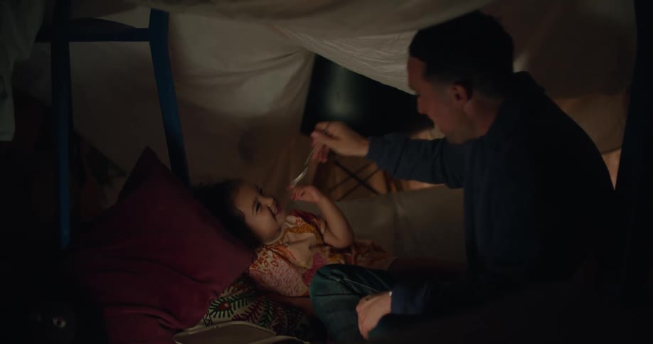 A man feeds a child food