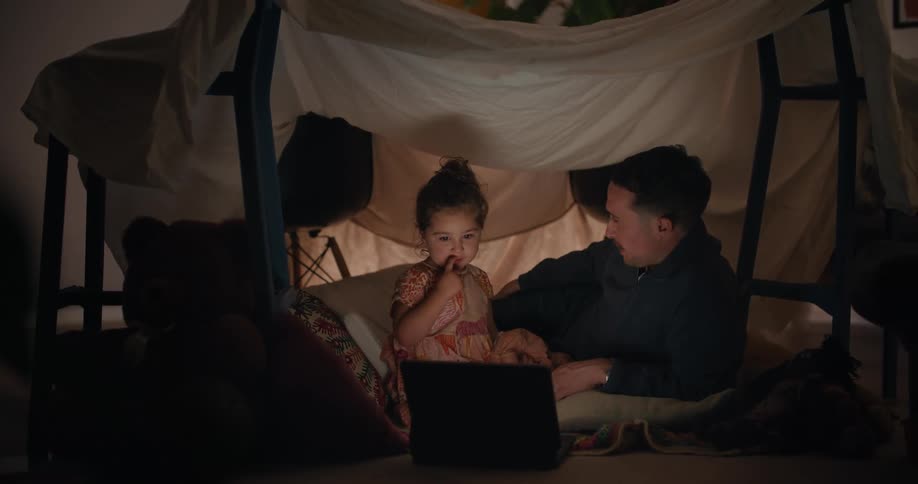 A man and child watch the the laptop together