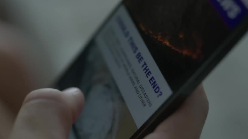 A person is texting on a cellphone and looking at news