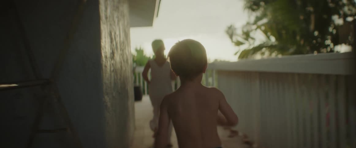 A boy chases after his sister running on the wrap around deck