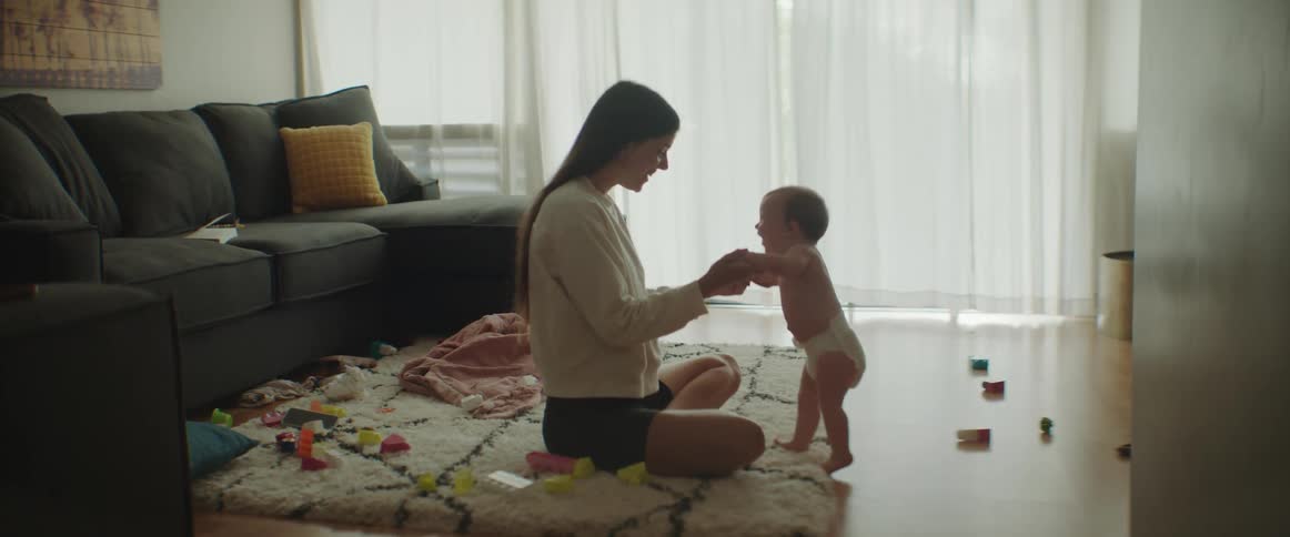 A mother is playing with her child in the living room