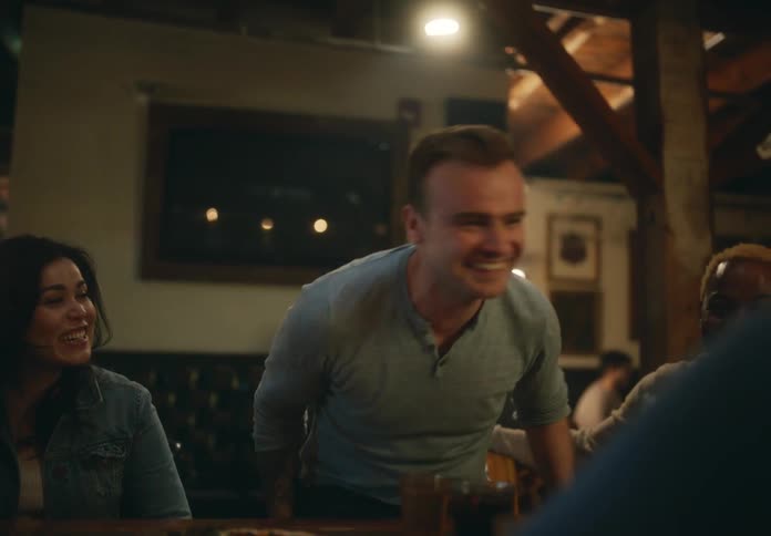 Friends sit together having drinks and pizza