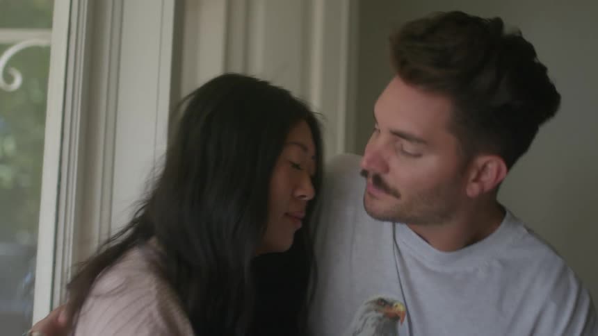 A man hugs and kisses his wife