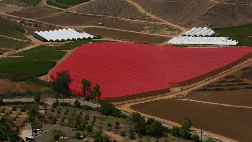 An aerial view of fields with crops covered up