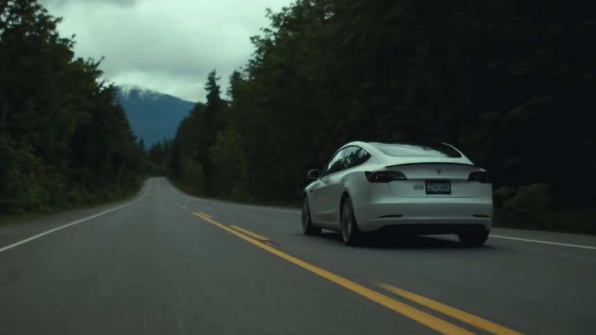 The white car drives on the long road