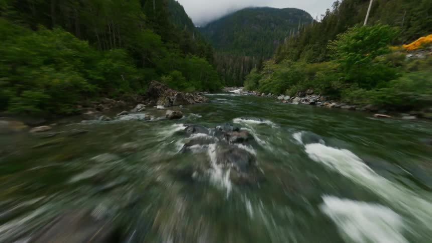 A narrow river runs through shrubland in a canyon