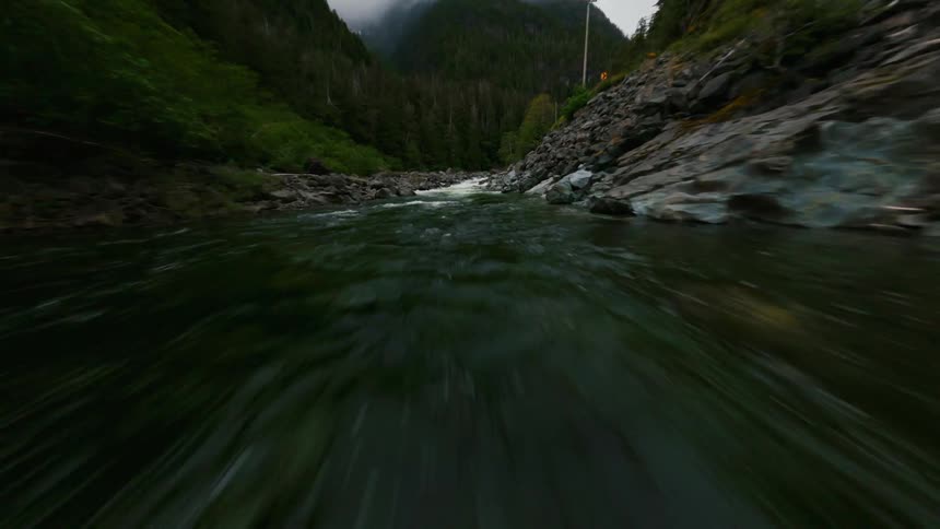 A river is flowing through a mountainous area in spring