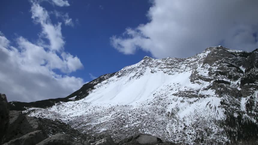 Clouds move over a snow covered mountain