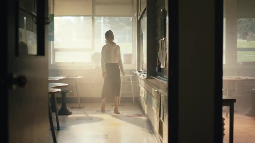 Elementary teacher cleaning a blackboard on a classroom at morning